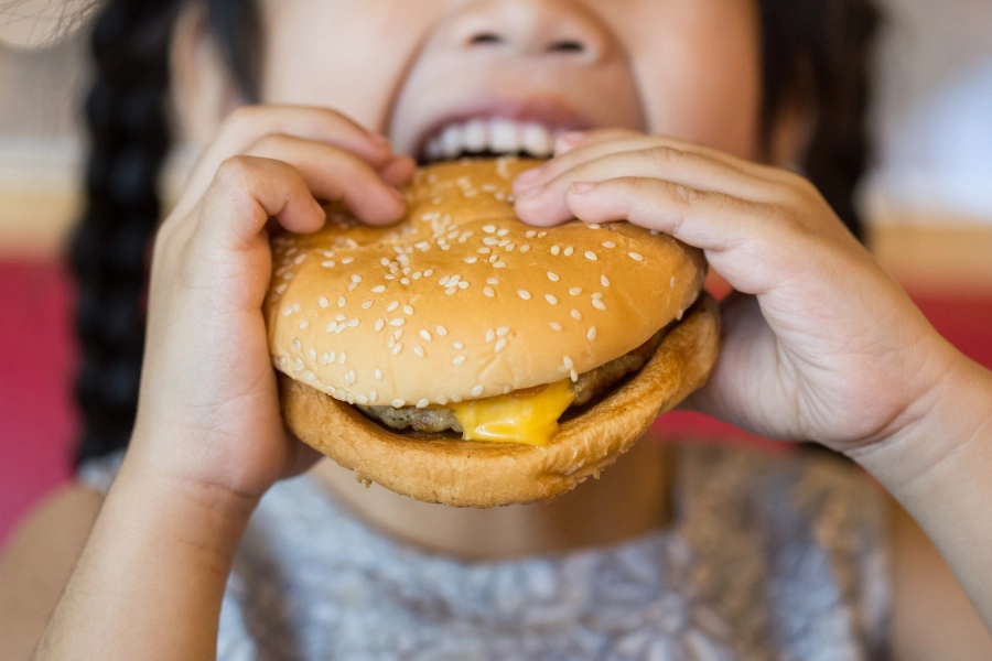 Young girl eating burger