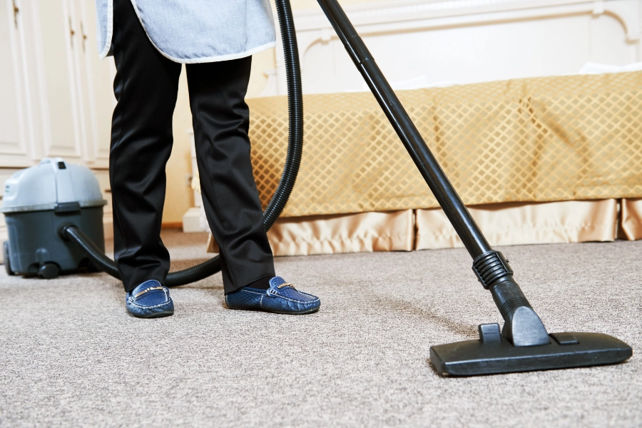 Cleaner hoovering hotel room