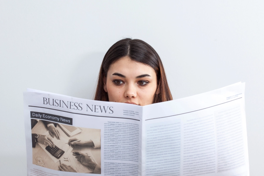 Woman reading business newspaper