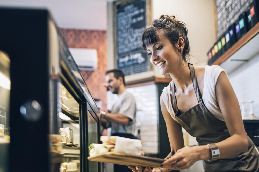 Woman carrying tray of food in cafe