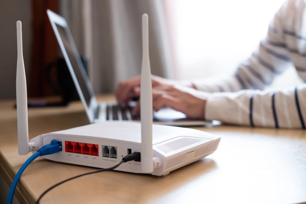 Broadband router on a desk with a laptop