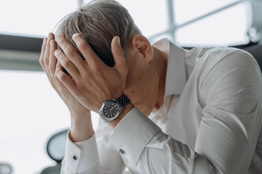 Stressed man with head in hands